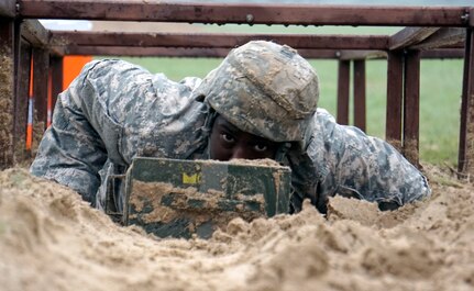 Spec. Gregory Stephens, JBSA-Fort Sam Houston Dental Activity, low crawls during one of 16 obstacle events during the Regional Best Warrior Competition hosted by the Joint Base San Antonio-Fort Sam Houston Dental Health Activity, or DENTAC, from Feb. 27 to March 3 at JBSA-Camp Bullis.