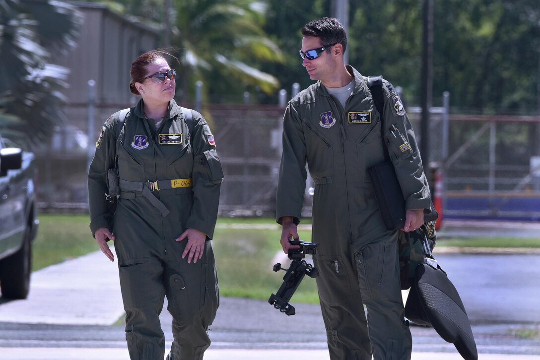 Puerto Rico Air National Guard Maj. Isbelia Reyes, left, and Capt. Mario Ibarra walk out to the flightline at Muñiz Air National Guard Base, Puerto Rico, before a flight to commemorate International Women's Day, March 8, 2017. Air National Guard photo by Staff Sgt. Angel Oquendo