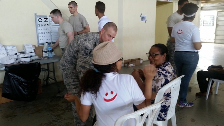 Maj. Jeffrey Newsom, 21st Medical Group Optometry flight commander, right rear in sand T-shirt, and Senior Airman Todd Stout, 21st MDG optometry technician, left rear, assist patients in the optometry clinic in Azua, Dominican Republic during Operation New Horizons, an exercise run by Air Force South, March 3-18, 2017. A team from 21st Medical Group, Peterson Air Force Base, Colo., is leading the initial phase of the exercise for the first time since the operation began in 2008. (Courtesy photo)