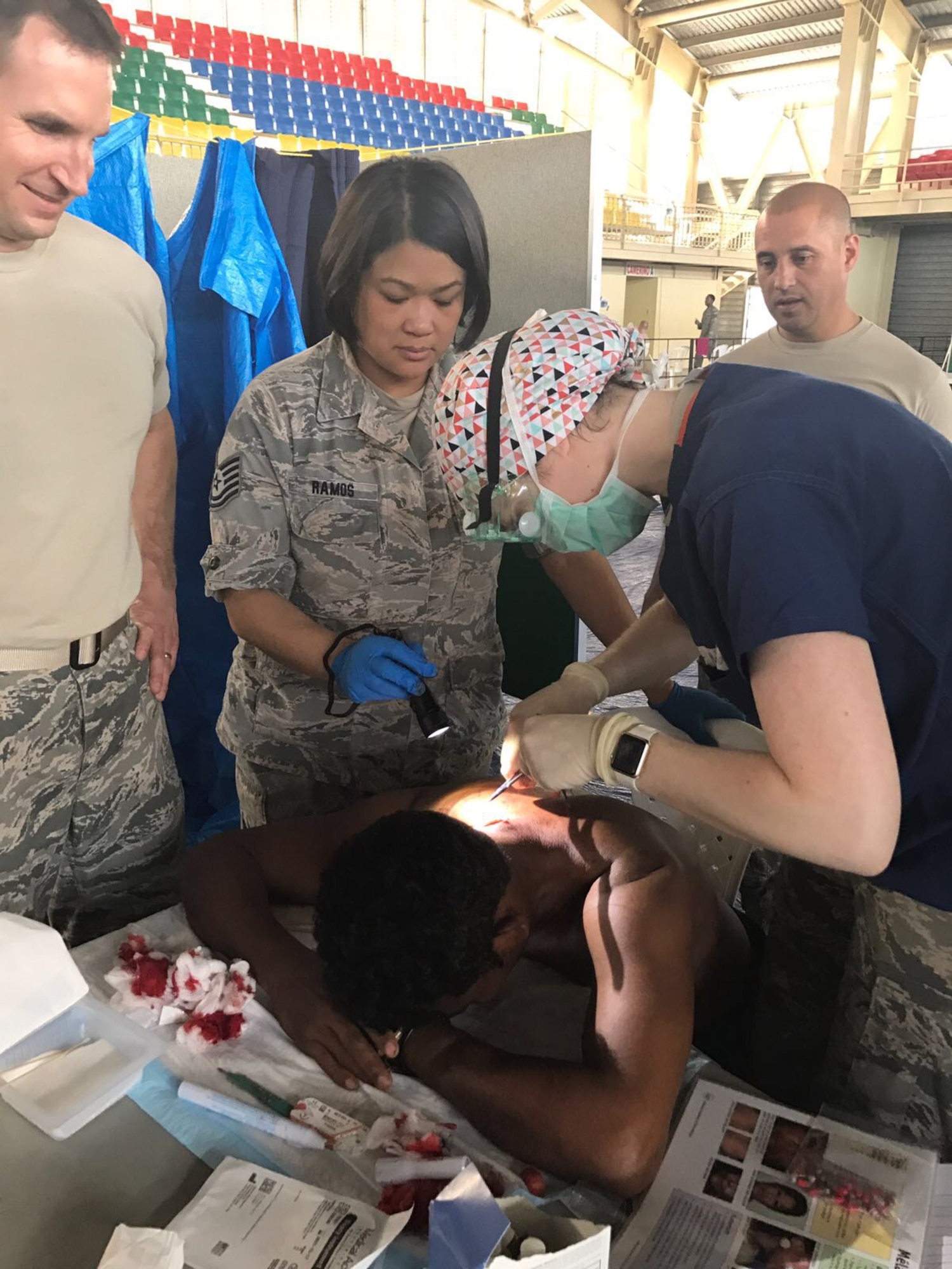 Tech Sgt. Allita Ramos, 21st Medical Group medical technician, assists with stitching a patient in Azua, Dominican Republic, during Operation New Horizons, an exercise run by Air Force South, March 3-18, 2017. A group from 21st Medical Group, Peterson Air Force Base, Colo., is leading the initial phase of the exercise for the first time since the operation began almost 20 years ago. (Courtesy photo)