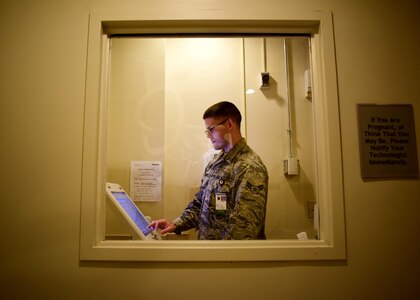 U.S. Air Force Airman 1st Class John Dennis, 633rd Surgical Operations Squadron diagnostics imaging technologist, prepares to perform an x-ray, at Joint Base Langley-Eustis, Va., Feb. 21, 2017. During their visit to the radiology department, patients are brought back to a room, where they are informed and positioned for their procedure. The decision on the appropriate technique, as far as how much radiation and radiation power to use, is made by the technologist. (U.S. Air Force photo/Senior Airman Areca T. Bell)