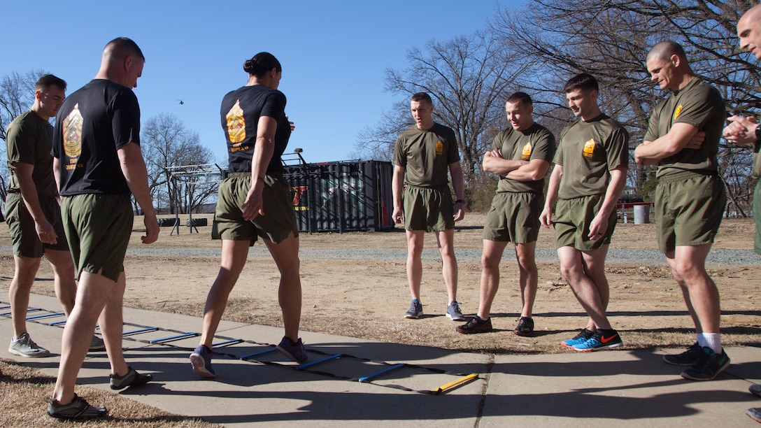 Staff Sgt. Robyn Czuri, a faculty advisor at the Marine Corps Base Quantico Staff Noncommissioned Officer Academy, demonstrates correct form for an exercise drill during physical training at MCB Quantico, Virginia, Mar. 8, 2017. Enlisted Marines come to Quantico in order to be qualified and teach as a faculty advisor, a role that helps facilitate hundreds of Marines a year in their resident professional military education.