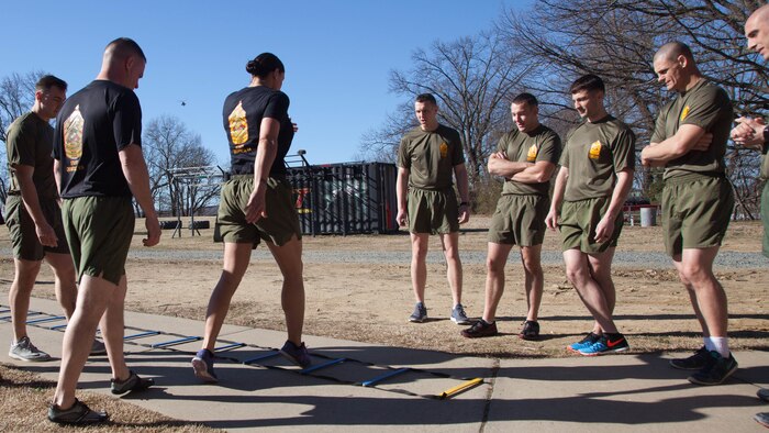 Staff Sgt. Robyn Czuri, a faculty advisor at the Marine Corps Base Quantico Staff Noncommissioned Officer Academy, demonstrates correct form for an exercise drill during physical training at MCB Quantico, Virginia, Mar. 8, 2017. Enlisted Marines come to Quantico in order to be qualified and teach as a faculty advisor, a role that helps facilitate hundreds of Marines a year in their resident professional military education.