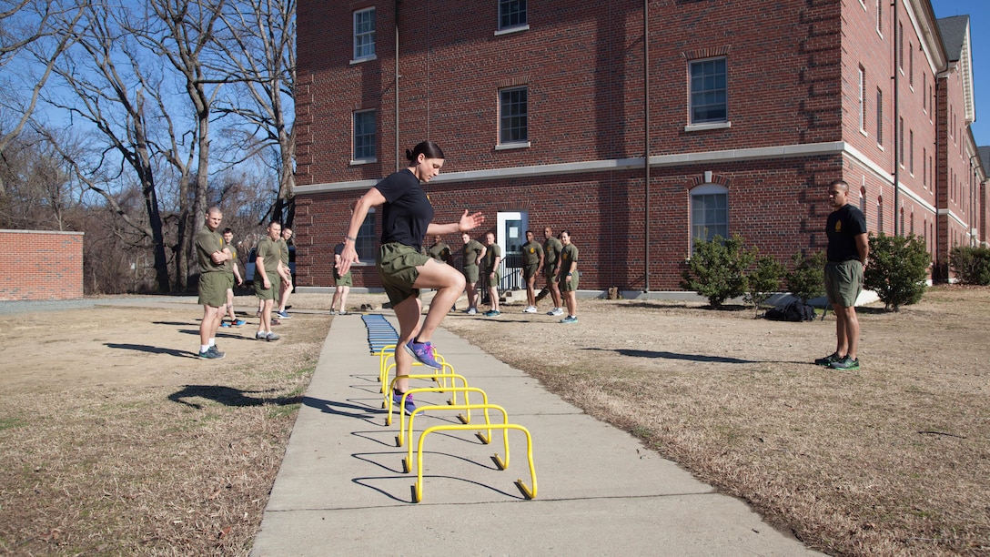 Staff Sgt. Robyn Czuri, a faculty advisor at the Marine Corps Base Quantico Staff Noncommissioned Officer Academy, demonstrates correct form for an exercise drill during physical training at MCB Quantico, Virginia, Mar. 8, 2017. Enlisted Marines come to Quantico in order to be qualified and teach as a faculty advisor, a role that helps facilitate hundreds of Marines a year in their resident professional military education.