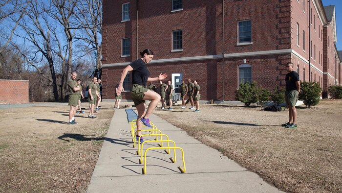 Staff Sgt. Robyn Czuri, a faculty advisor at the Marine Corps Base Quantico Staff Noncommissioned Officer Academy, demonstrates correct form for an exercise drill during physical training at MCB Quantico, Virginia, Mar. 8, 2017. Enlisted Marines come to Quantico in order to be qualified and teach as a faculty advisor, a role that helps facilitate hundreds of Marines a year in their resident professional military education.