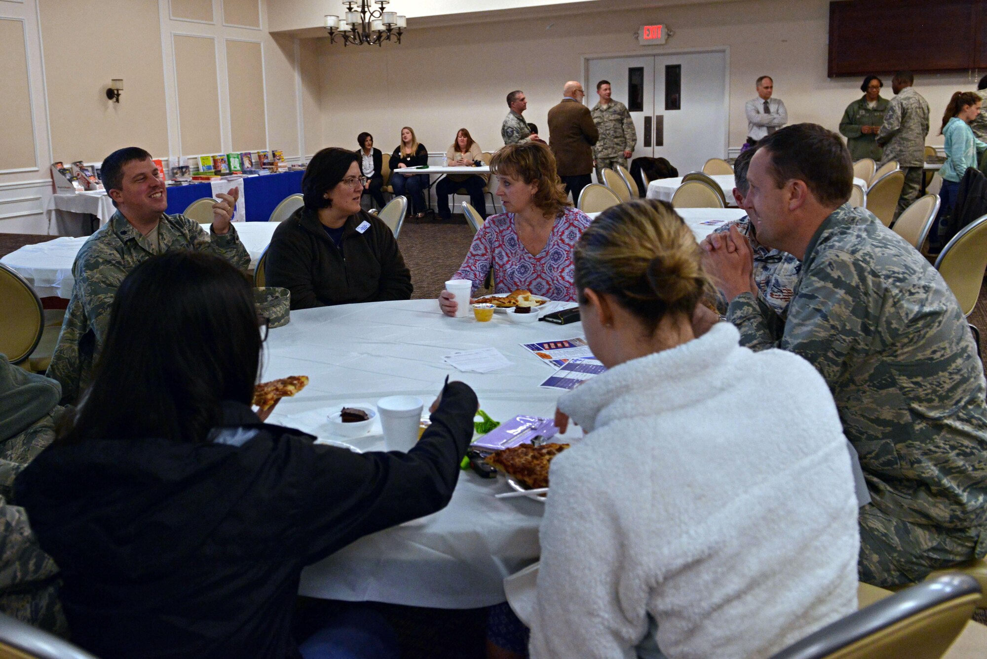Maggie Catoe, 20th Medical Support Squadron key spouse mentor, center left, speaks with individuals from her squadron during a pre-deployment dinner at the Carolina Skies and Conference Center at Shaw Air Force Base, S.C., March 13, 2017. Key spouses help welcome families to Team Shaw and act as liaisons between spouses and helping agencies. (U.S. Air Force photo by Airman 1st Class Destinee Sweeney)