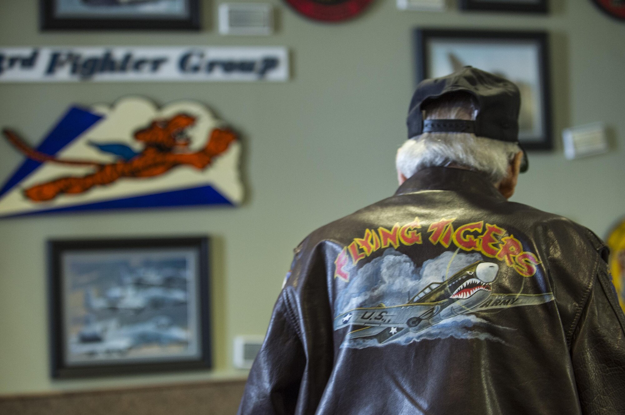 J.M. Taylor, World War II veteran and prisoner of war, looks at a heritage display during the 75th Anniversary Flying Tiger Reunion, March 10, 2017, at Moody Air Force Base, Ga. In 1941, President Roosevelt signed an executive order forming the American Volunteer Group. The AVG was organized into the 1st, 2nd, and 3rd Pursuit Squadrons and later disbanded and replaced by the 23d Fighter Group in 1942. Under the command of Gen. Claire Chennault, the Flying Tigers comprised of the 74th, 75th, and 76th Pursuit Squadrons defended China against the Japanese. Throughout World War II, the Flying Tigers achieved combat success and flew the US-made Curtiss P-40 Warhawks painted with the shark-mouth design. (U.S. Air Force photo by Senior Airman Ceaira Young)
