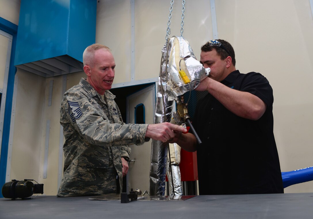 Dave Darling, the “Cold Spray” site lead assigned to the 28th Maintenance Squadron, briefs Chief Master Sgt. Alan Boling, command chief for the 8th Air Force, on the “Cold Spray” technology initiative during a visit to Ellsworth Air Force Base, S.D., March 8, 2017. “Cold Spray” is the process in which small particles of the material are accelerated to achieve a mechanical bond upon impact, restoring the part back to the original specifications. (U.S. Air Force photo by Airman 1st Class Donald C. Knechtel)