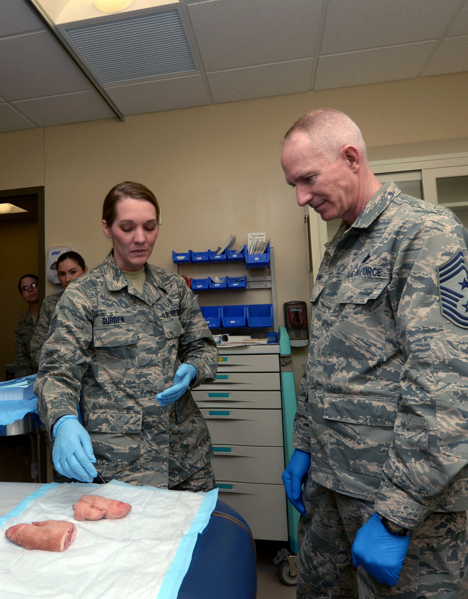 Tech. Sgt. Ashley Gurden, an aerospace medical technician assigned to the 28th Medical Operations Squadron, performs a demonstrative suturing on a pigs foot with Chief Master Sgt. Alan Boling, command chief for the 8th Air Force, during a visit to Ellsworth Air Force Base, S.D., March 8, 2017. During his visit, Boling also visited the Raider Café, 28th Logistics Readiness Squadron Deployment Center, Pride Hangar and more. (U.S. Air Force photo by Airman 1st Class Donald C. Knechtel)