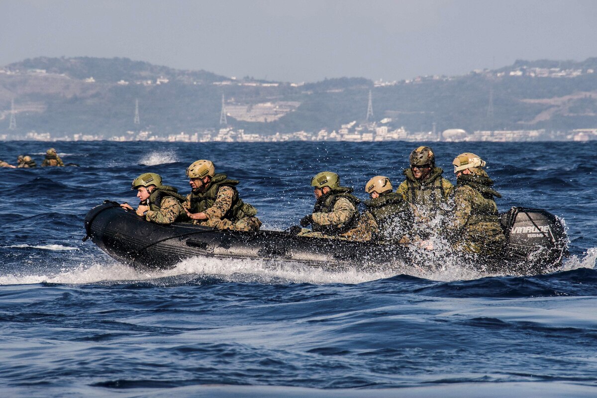 Marines ride in a rubber raiding craft.