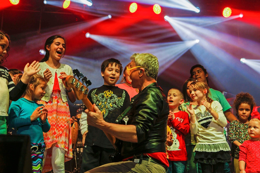 Gary Sinise, electric bassist, interacts with children on stage during family day activities at Camp Lejeune, N.C., March 5, 2017.  Marine Corps photo by Lance Cpl. Ursula V. Estrella