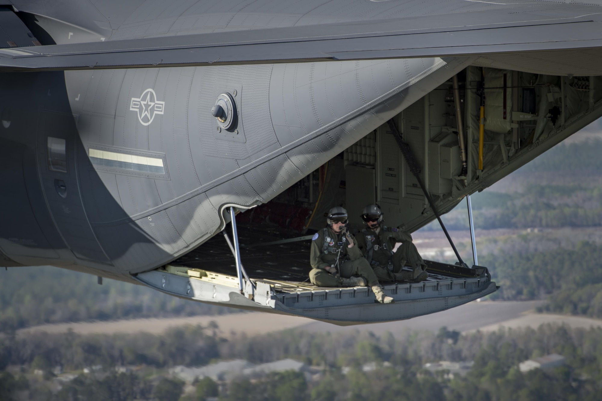 Senior Airman Timothy Foote and Master Sgt. Jerome Ware, 71st Rescue Squadron loadmasters, sit on the ramp of an HC-130J Combat King II during a combat search and rescue demonstration at the 75th Anniversary Flying Tiger Reunion, March 10, 2017, at Moody Air Force Base, Ga. In 1941, President Roosevelt signed an executive order forming the American Volunteer Group. The AVG was organized into the 1st, 2nd, and 3rd Pursuit Squadrons and later disbanded and replaced by the 23d Fighter Group in 1942. Under the command of Gen. Claire Chennault, the Flying Tigers comprised of the 74th, 75th, and 76th Pursuit Squadrons defended China against the Japanese. Throughout World War II, the Flying Tigers achieved combat success and flew the US-made Curtiss P-40 Warhawks painted with the shark-mouth design. (U.S. Air Force photo by Tech. Sgt. Zachary Wolf)