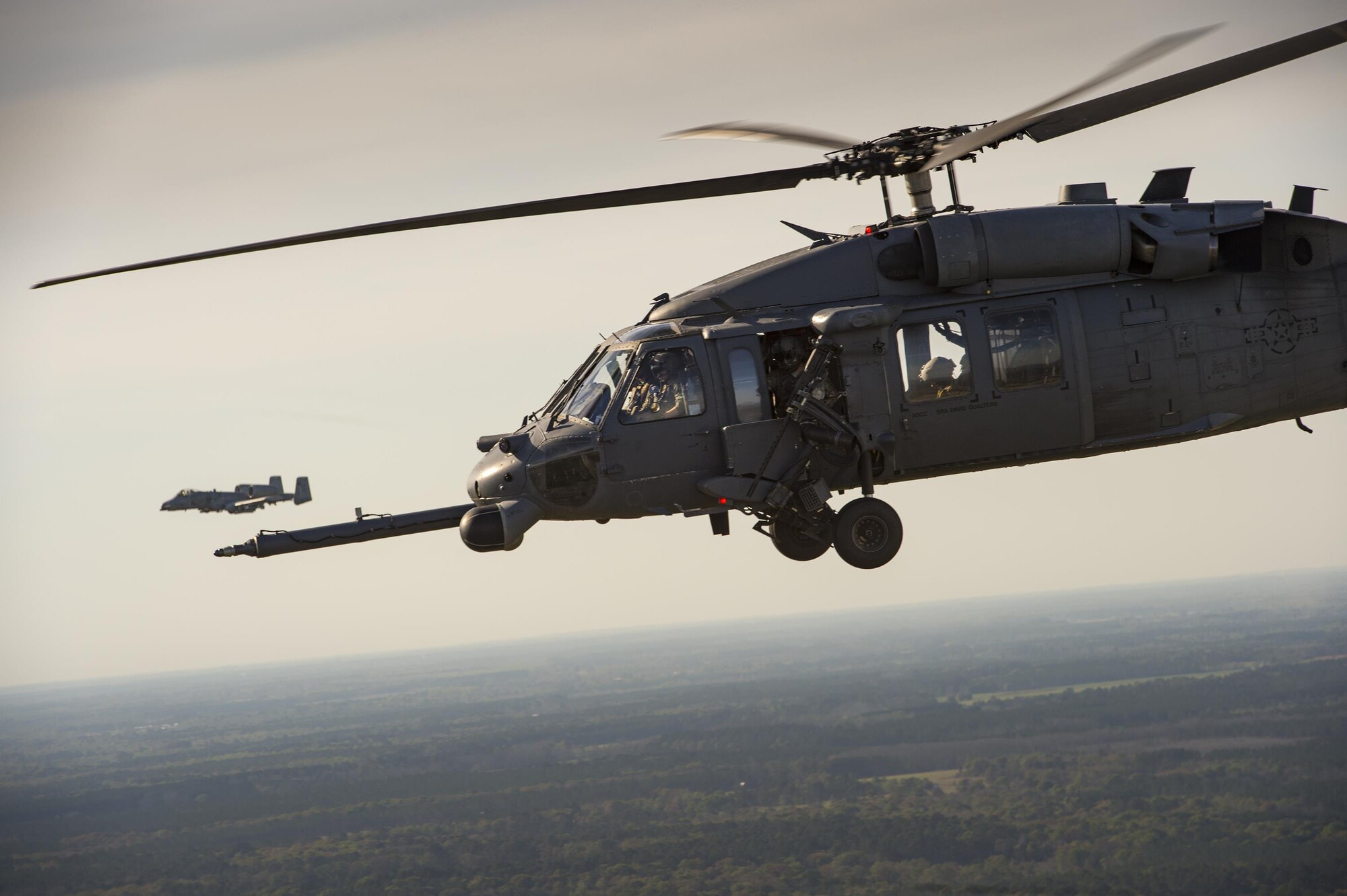 An HH-60G Pave Hawk and an A-10C Thunderbolt II fly as part of a combat Search and rescue demonstration during the 75th Anniversary Flying Tiger Reunion, March 10, 2017, at Moody Air Force Base, Ga. In 1941, President Roosevelt signed an executive order forming the American Volunteer Group. The AVG was organized into the 1st, 2nd, and 3rd Pursuit Squadrons and later disbanded and replaced by the 23d Fighter Group in 1942. Under the command of Gen. Claire Chennault, the Flying Tigers comprised of the 74th, 75th, and 76th Pursuit Squadrons defended China against the Japanese. Throughout World War II, the Flying Tigers achieved combat success and flew the US-made Curtiss P-40 Warhawks painted with the shark-mouth design. (U.S. Air Force photo by Tech. Sgt. Zachary Wolf)