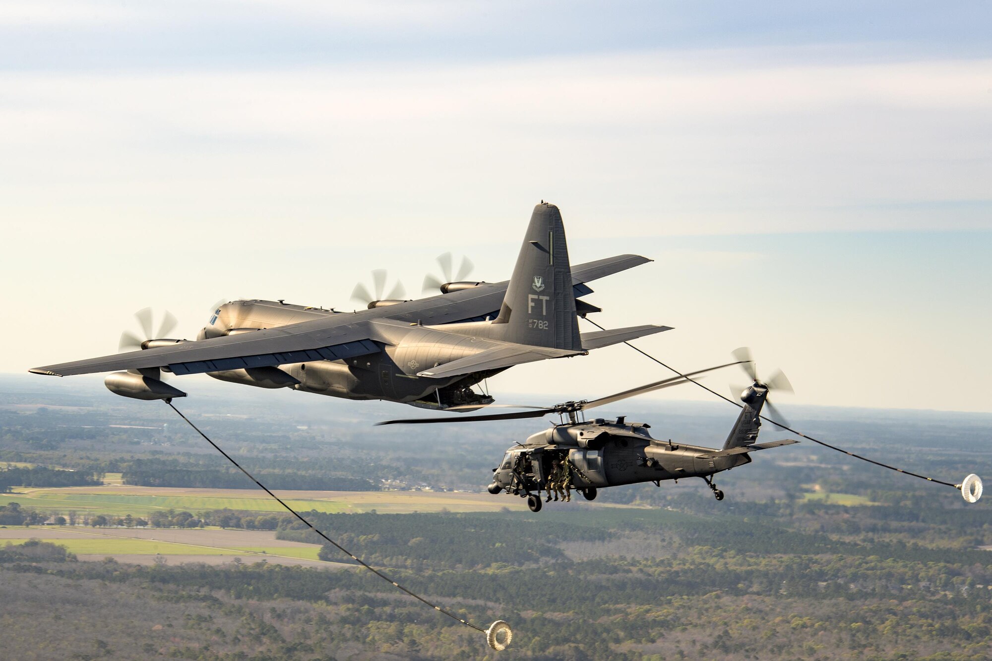 Refuel
An HC-130J Combat King II and an HH-60G Pave Hawk conduct a refueling demonstration during the 75th Anniversary Flying Tiger Reunion, March 10, 2017, at Moody Air Force Base, Ga. In 1941, President Roosevelt signed an executive order forming the American Volunteer Group. The AVG was organized into the 1st, 2nd, and 3rd Pursuit Squadrons and later disbanded and replaced by the 23d Fighter Group in 1942. Under the command of Gen. Claire Chennault, the Flying Tigers comprised of the 74th, 75th, and 76th Pursuit Squadrons defended China against the Japanese. Throughout World War II, the Flying Tigers achieved combat success and flew the US-made Curtiss P-40 Warhawks painted with the shark-mouth design. (U.S. Air Force photo by Staff Sgt. Ryan Callaghan)
