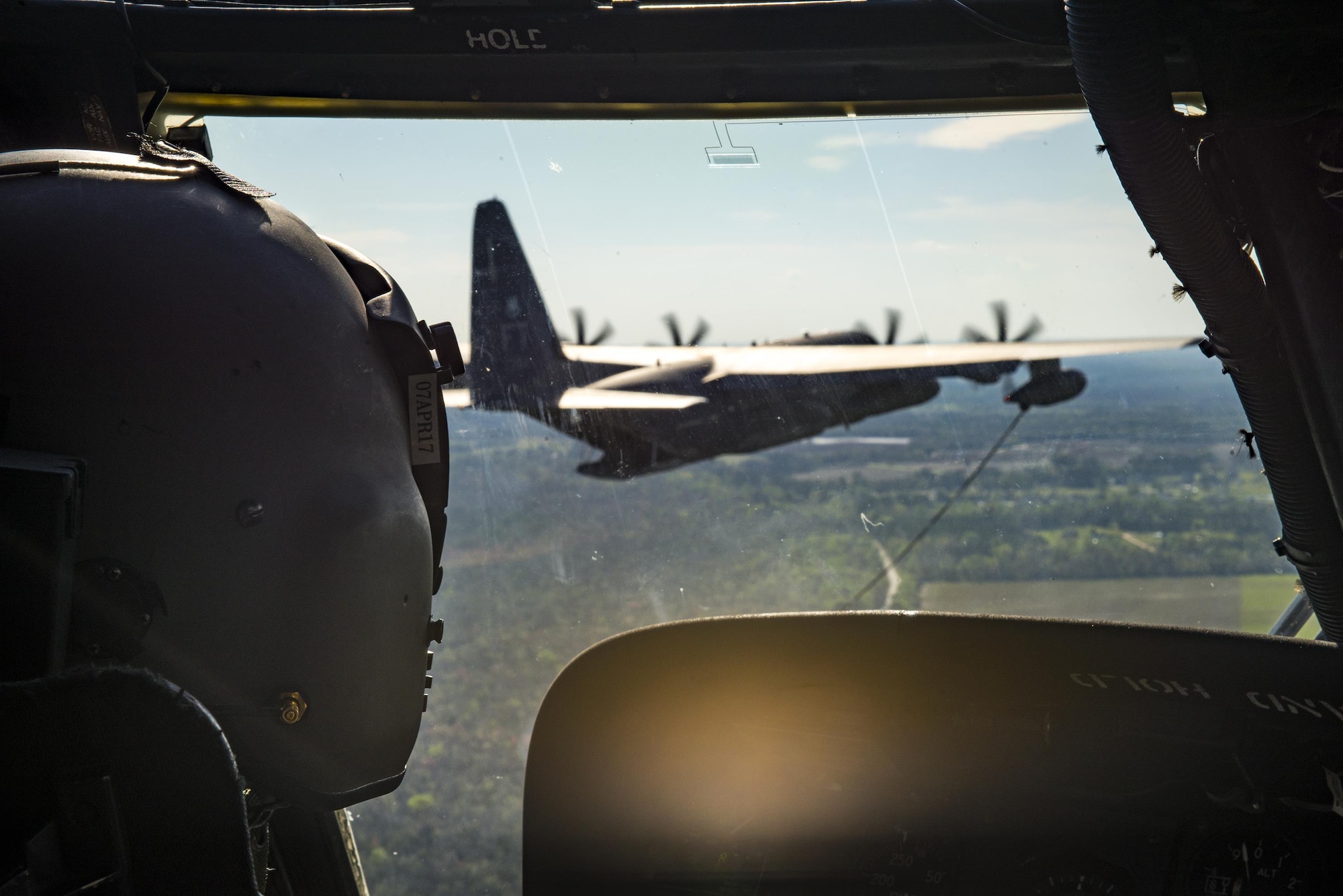 An HH-60G Pave Hawk pilot from the 41st Rescue Squadron flies towards an HC-130J Combat King II as part of a refueling demonstration during the 75th Anniversary Flying Tiger Reunion, March 10, 2017, at Moody Air Force Base, Ga. In 1941, President Roosevelt signed an executive order forming the American Volunteer Group. The AVG was organized into the 1st, 2nd, and 3rd Pursuit Squadrons and later disbanded and replaced by the 23d Fighter Group in 1942. Under the command of Gen. Claire Chennault, the Flying Tigers comprised of the 74th, 75th, and 76th Pursuit Squadrons defended China against the Japanese. Throughout World War II, the Flying Tigers achieved combat success and flew the US-made Curtiss P-40 Warhawks painted with the shark-mouth design. (U.S. Air Force photo by Staff Sgt. Ryan Callaghan)