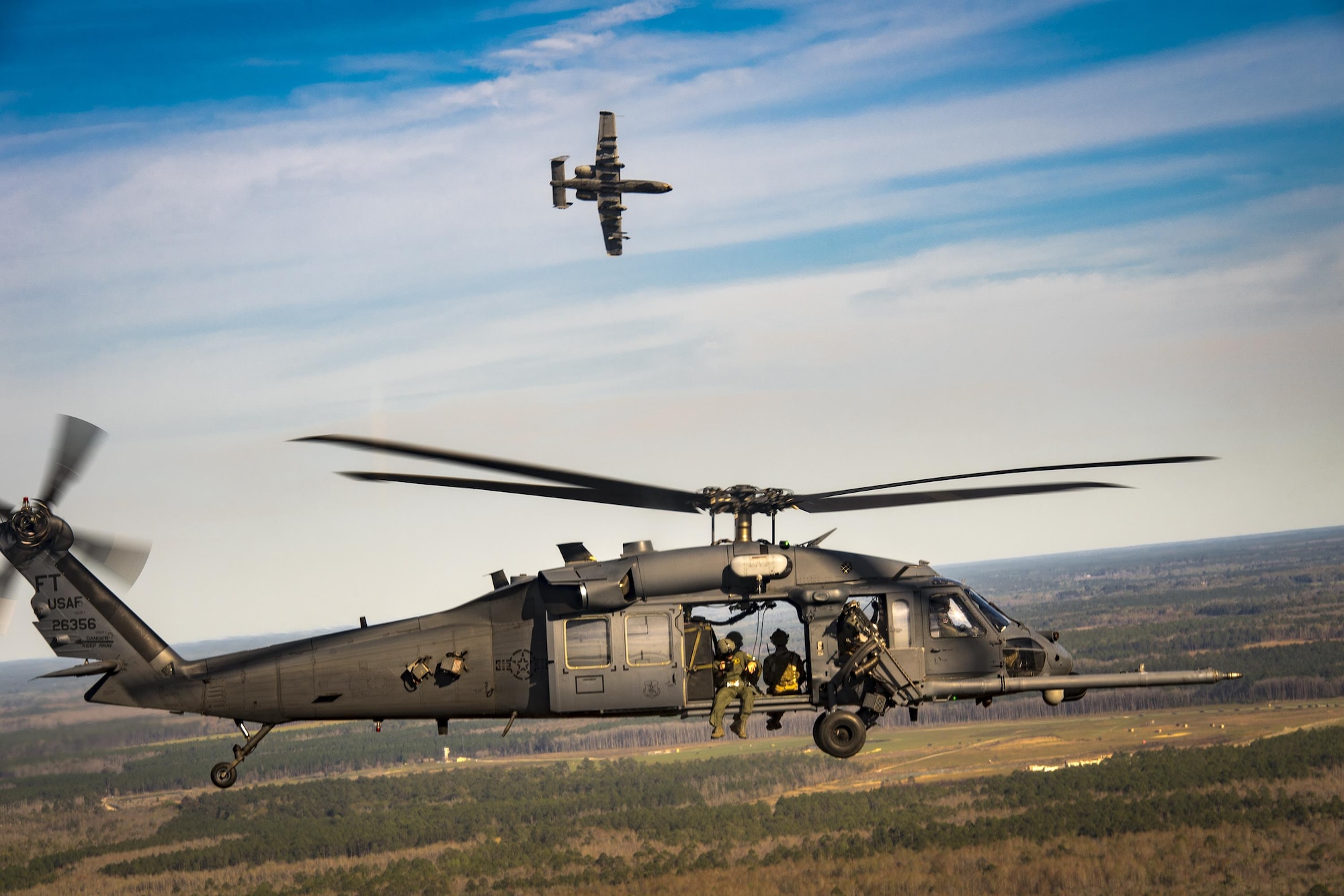 An A-10C Thunderbolt II from the 23d Fighter Group escorts an HH-60G Pave Hawk as part of a combat search and rescue demonstration during the 75th Anniversary Flying Tiger Reunion, March 10, 2017, at Moody Air Force Base, Ga. In 1941, President Roosevelt signed an executive order forming the American Volunteer Group. The AVG was organized into the 1st, 2nd, and 3rd Pursuit Squadrons and later disbanded and replaced by the 23d Fighter Group in 1942. Under the command of Gen. Claire Chennault, the Flying Tigers comprised of the 74th, 75th, and 76th Pursuit Squadrons defended China against the Japanese. Throughout World War II, the Flying Tigers achieved combat success and flew the US-made Curtiss P-40 Warhawks painted with the shark-mouth design. (U.S. Air Force photo by Staff Sgt. Ryan Callaghan)