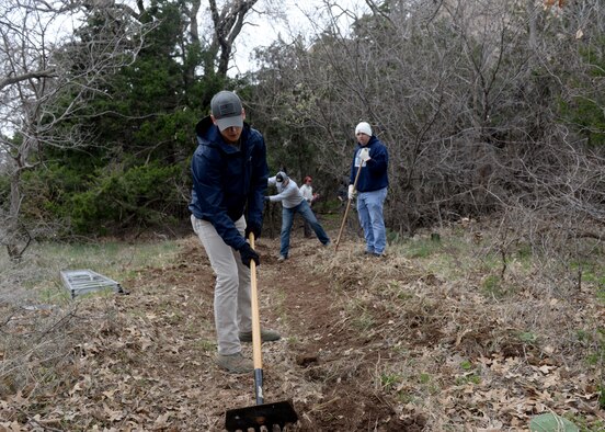 U.S. Air Force Airman First Class Brendan Smith, 97th Training Squadron student, rakes a trail, at Quartz Mountain Nature Park, Oklahoma, March 11, 2017. 97th TRS Airmen cleared trails of brush and debris to help beautify the Quartz Mountain Nature Park and make it safer for the community. (U.S. Air Force Photo by Airman 1st Class Jackson N. Haddon/Released).