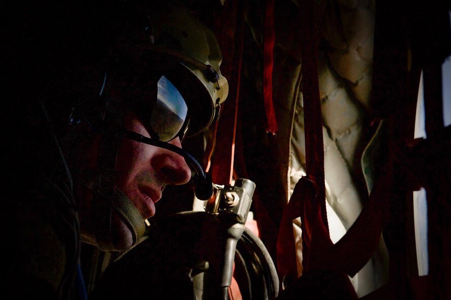 A Survival, Evasion, Resistance, and Escape specialist looks out the window of a CH-47 Chinook before performing a static-line jump during Red Flag 17-2 over the Nevada Test and Training Range, Nev., March 7, 2017. The CH-47 Chinook is an American twin-engine, tandem rotor heavy-lift helicopter. (U.S. Air Force photo by Airman 1st Class Kevin Tanenbaum/Released)