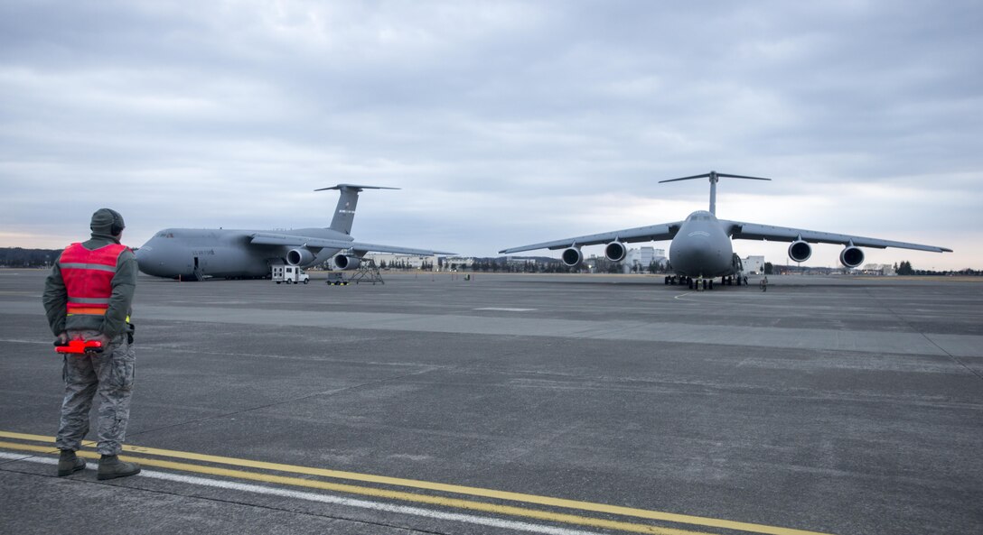 An Airman from the 730th Air Mobility Squadron waits to taxi a Travis Air Force Base, California, C-5M Super Galaxy March 7, 2017 prior to a flight from Yokota Air Base, Japan to Osan Air Base, South Korea. The C-5M was on a Pacific channel mission, delivering cargo to Japan, South Korea and other parts of the Pacific Region. (U.S. Air Force photo/Staff Sgt. Nicole Leidholm)