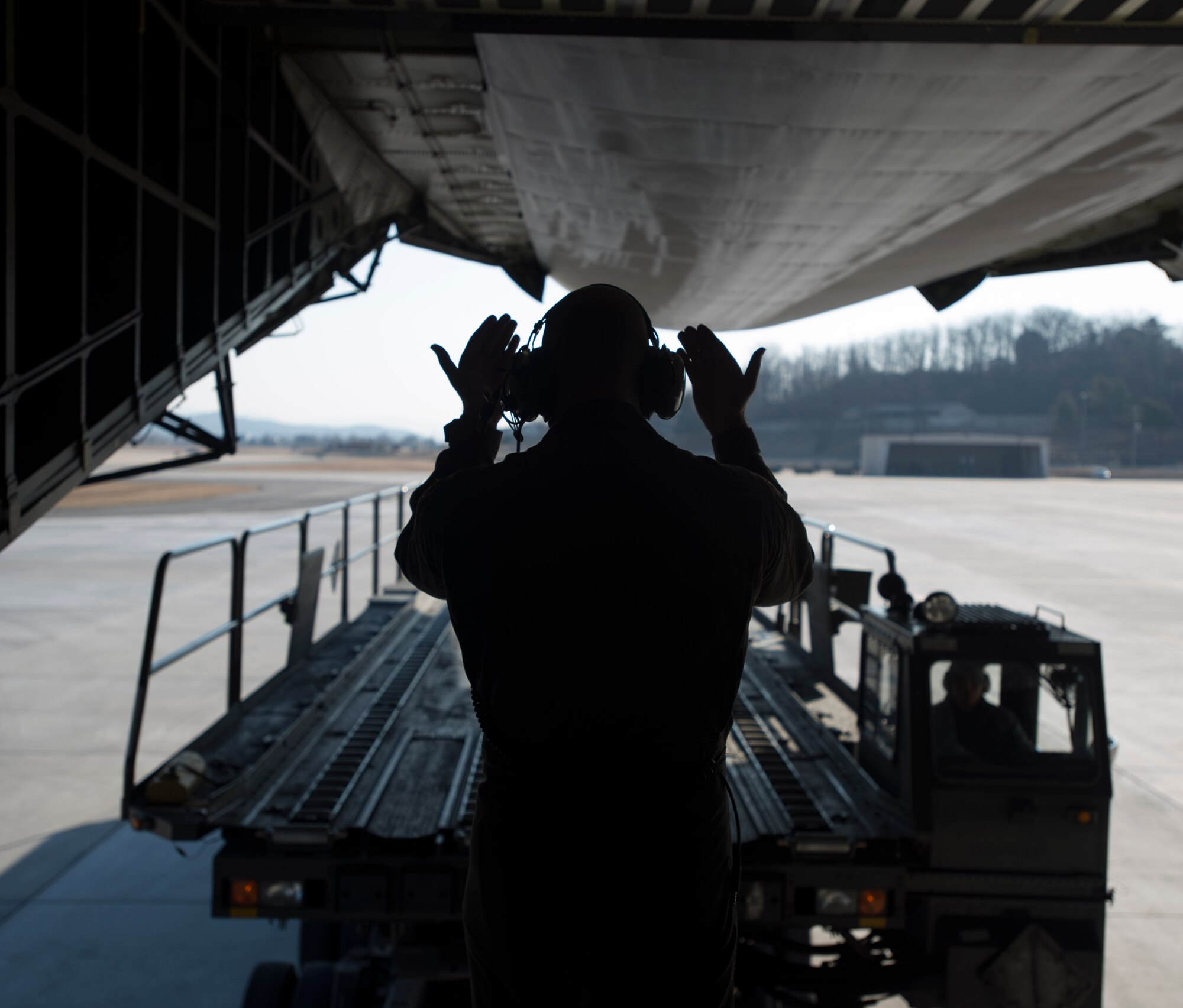 Senior Airman Elias Wilson, 22nd Airlift Squadron, marshalls in a K-loader to offload cargo after landing March 7, 2017, at Osan Air Base, South Korea. Nearly 70,000 pounds of cargo were offloaded at Osan AB. (U.S. Air Force photo by Staff Sgt. Nicole Leidholm)
