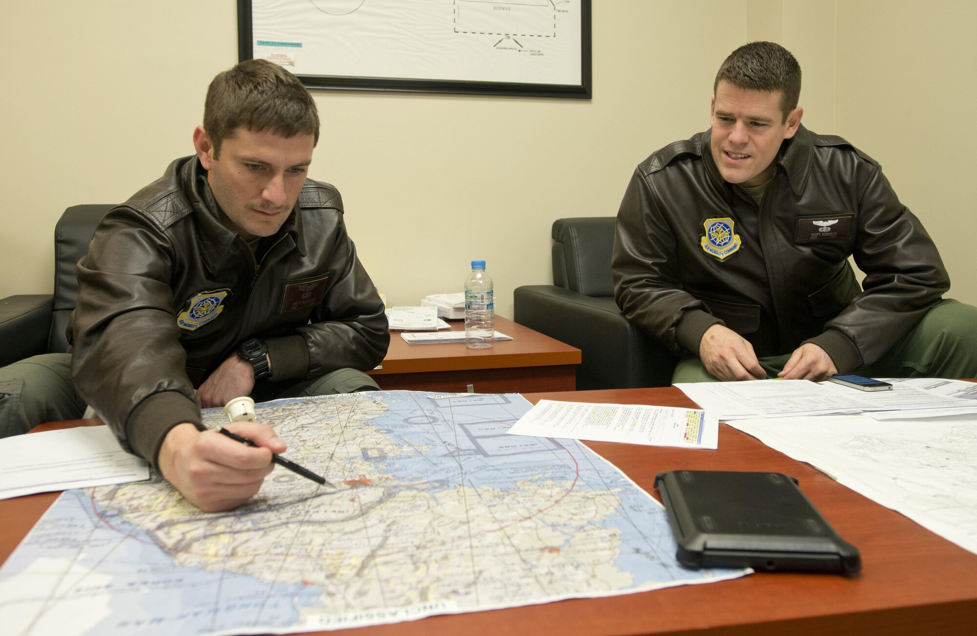 Capt. Brett Boudreaux, left, and Capt. Scott Robinson, assigned to the 22nd Airlift Squadron, go over the flight plan March 9, 2017, for the day's mission from Osan Air Base, South Korea, to Yokota Air Base, Japan. The pilots were on what's called a Pacific channel mission, flying cargo from Osan AB to Travis Air Force Base, California. (U.S. Air Force photo by Staff Sgt. Nicole Leidholm)