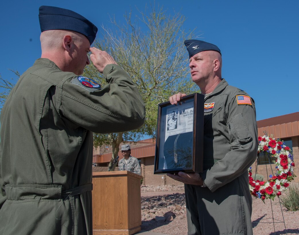 Col. Edwin Slocum, vice wing commander of the 161st Air Refueling Wing, accepts the identification tag of Tech. Sgt. Donald J. Plough donated to the wing during 35th Annual Copper 5 Memorial at the Goldwater Air National Guard Base, Mar. 13. Plough was the boom operator and crew member aboard Copper 5, Boeing KC-135A Stratotanker aerial refueling jet from the 161st that was involved in a mid-air collision with a civilian plane, killing the four person aircrew on Mar. 13, 1982.