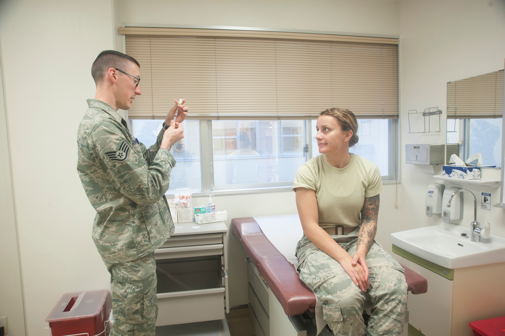 U.S. Air Force Staff Sgt. Joshua Orlandt, allergy and immunizations technician (left), prepares a shot for U.S. Air Force Senior Airman Kattie Savoy, 18th Civil Engineer Squadron civil engineer March 14, 2017, at Kadena Air Base, Japan. Viruses are dangerous, uncomfortable and potentially deadly. Despite this, many of the most common have vaccines that can minimize their symptoms or even prevent them altogether. (U.S. Air Force photo by Airman 1st Class Quay Drawdy)