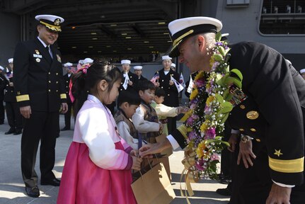 Rear Adm. James W. Kilby, commander, Carrier Strike Group 1 gives a gift to a Republic of Korea (ROK) child during a gift exchange as part of USS Carl Vinson's (CVN-70) arrival to ROK Fleet headquarters as part as a routine port visit. The Carl Vinson Carrier Strike Group is on a regularly scheduled Western Pacific deployment as part of the U.S. Pacific Fleet-led initiative to extend the command and control functions of U.S. 3rd Fleet. 