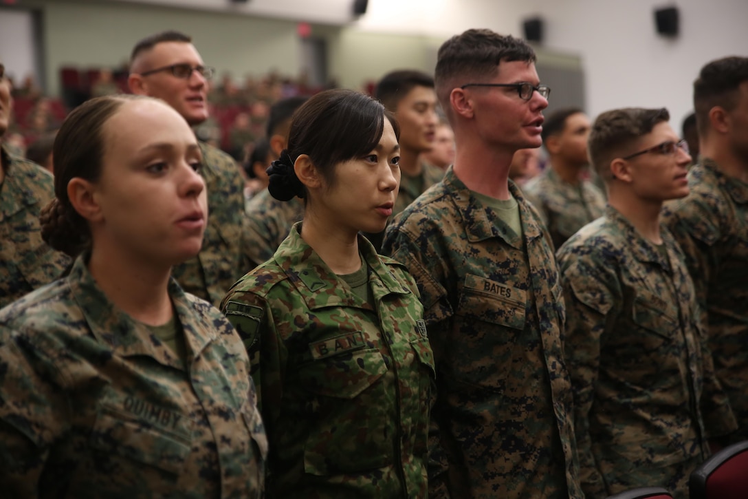 Japan Ground Self-Defense Force Sgt. Mizuho Ban recites the Noncommissioned Officers Creed with her class during their graduation of Corporal’s Course Feb. 10 aboard Camp Foster, Okinawa, Japan. Ban travelled over 700 miles from Chitose City, Hokkaido, Japan, to attend the course with Marines, sailors and airmen. Ban is a radio communicator with 1st Electronic Warfare Unit, 2nd Direction Finding Company. 