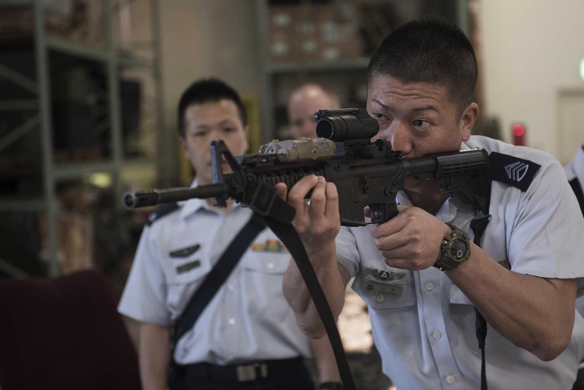 Members of the Japan Air Self-Defense Force learn about and handle different weapons during a tour of the Security Forces Squadron March. 14, 2017, at Kadena Air Base, Japan. They were then given a tour of the Squadron and its different sections, such as the base defense operations center, investigations office and interview and holding cells. (U.S. Air Force photo by Airman 1st Class Corey Pettis/Released)