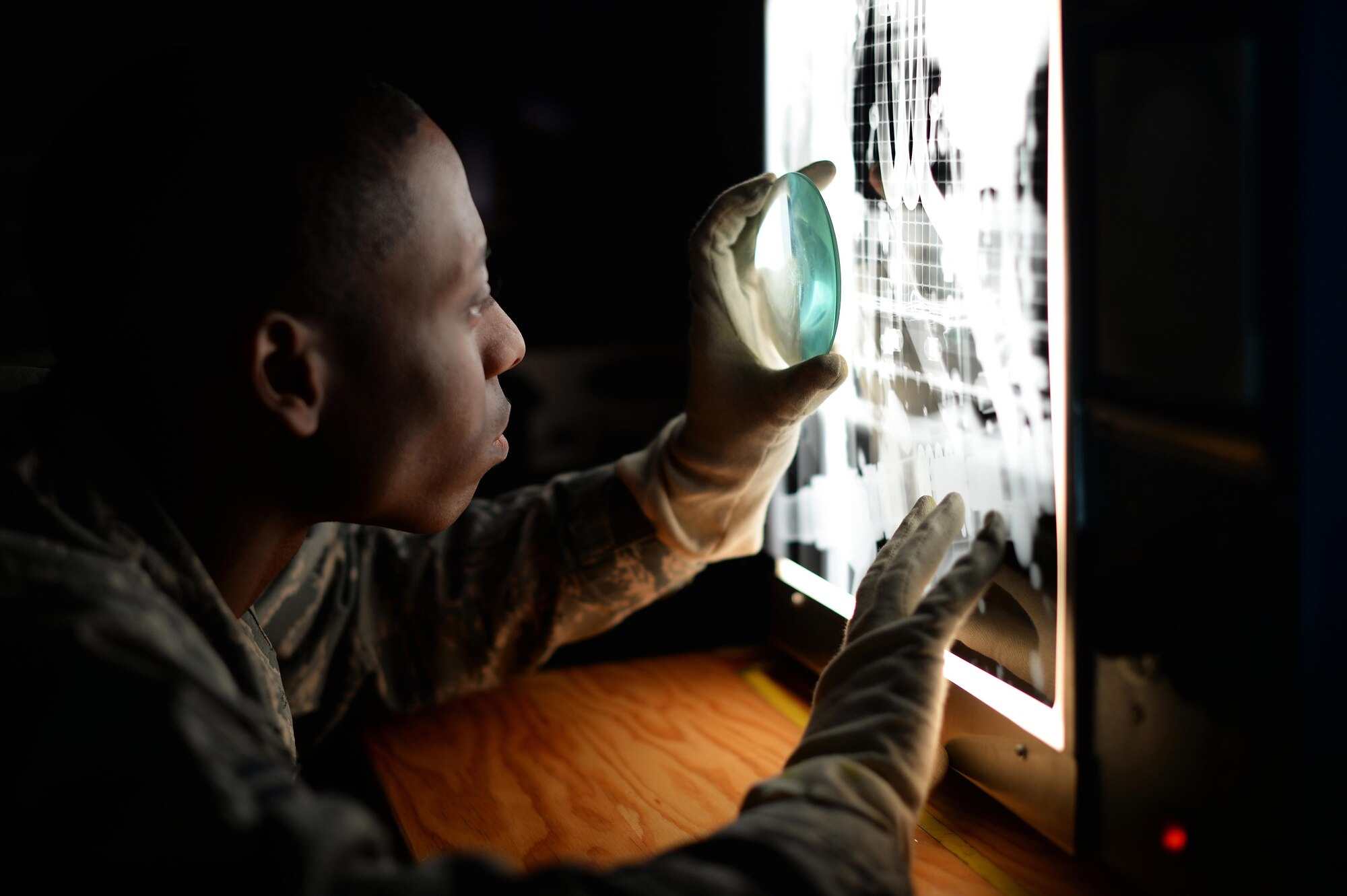 A 48th Equipment Maintenance Squadron nondestructive inspection journeyman examines x-ray film of an F-15 Eagle component on Royal Air Force Lakenheath, England, March 10, 2017. NDI Airmen are able to inspect aircraft for defects without having to deconstruct them completely, saving valuable time and money. (U.S. Air Force photo/Staff Sgt. Emerson Nuñez)