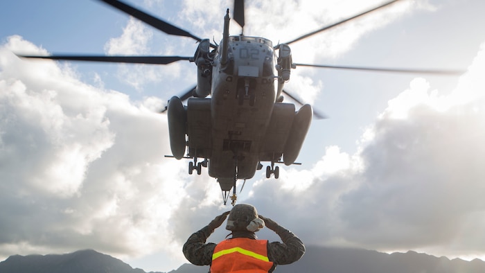 Pfc. Jose Camacho, a landing support specialist with Transportation Services Company, Combat Logistics Battalion 3, guides a CH-53E Super Stallion helicopter assigned to Marine Heavy Helicopter Squadron 463, during external lift training at Landing Zone West Field at Marine Corps Air Station Kaneohe Bay, Hawaii, March 8, 2017. This training improves proficiency for the pilots when moving supplies while Marines on the ground conditioned themselves to safely prepare dual and single load lifts. 