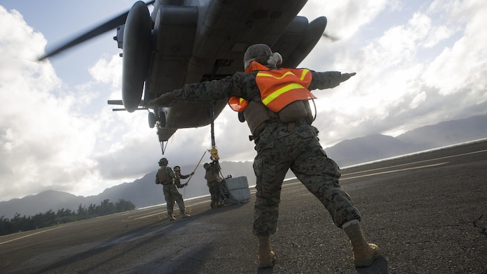 Pfc. Jose Camacho, a landing support specialist with Transportation Services Company, Combat Logistics Battalion 3, guides a CH-53E Super Stallion helicopter from Marine Heavy Helicopter Squadron 463, nicknamed “Pegasus,” during external lift training at Landing Zone West Field at Marine Corps Air Station Kaneohe Bay, Hawaii, March 8, 2017. This training improves proficiency for the pilots when moving supplies while Marines on the ground conditioned themselves to safely prepare dual and single load lifts.