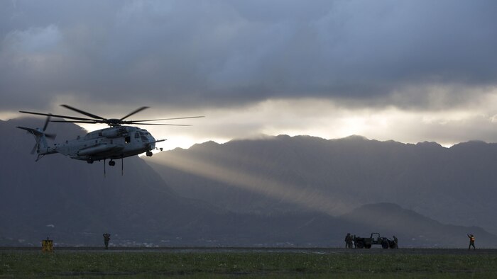 A landing support specialist with Transportation Services Company, Combat Logistics Battalion 3, guides a CH-53E Super Stallion helicopter assigned to Marine Heavy Helicopter Squadron 463, nicknamed “Pegasus,” during external lift training at Landing Zone West Field at Marine Corps Air Station Kaneohe Bay, Hawaii, March 8, 2017. This training improves proficiency for the pilots when moving supplies while Marines on the ground conditioned themselves to safely prepare dual and single load lifts.