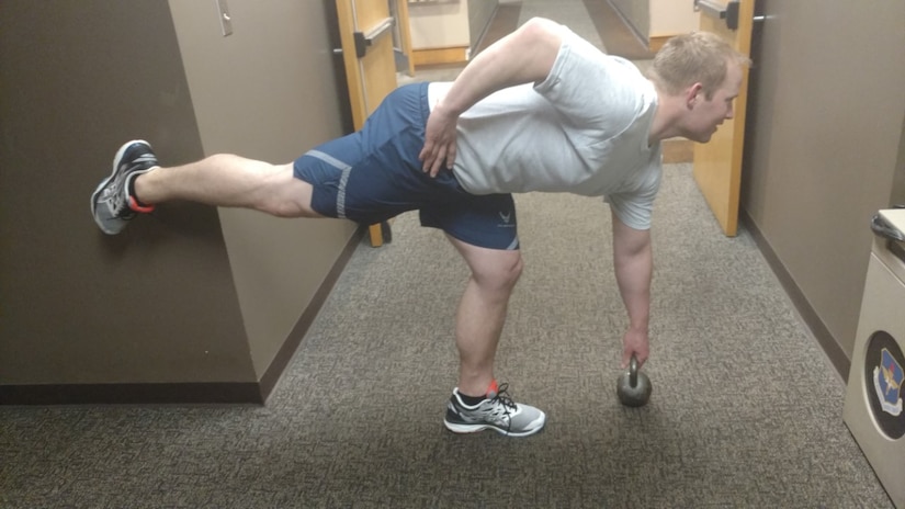 U.S. Air Force Capt. Dennis Shay, 628th Medical Group, performs a single legged, straight legged deadlift using a kettlebell. The lift is performed by standing on one leg with a kettle bell in your hand and bending forward to touch the ground with the kettle bell while lifting the other leg so it stays parallel with your torso.  This lift helps improves core strength, hamstring flexibility, and balance.  If you have any pain performing single leg dead lifts try to start by just performing to chair height rather than all the way to the ground for several weeks to build tolerance. Three sets of 10-15 repetitions is a good workout design to begin with.