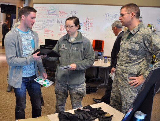 2nd Lt. Lt Brent Young, AFRL Junior Force Council member, right, makes a presentation about Junior Force Warfighter Operations in RX, or JFWORX, an AFRL/RX internally funded program aimed at future workforce development to attendees at the AFRL Business & Technology Showcase. JFWORX provides those new to the government an opportunity to solve immediate need, real-world problems for warfighters; an experience unique to traditional junior workforce development. (U.S. Air Force photo/Bryan Ripple)