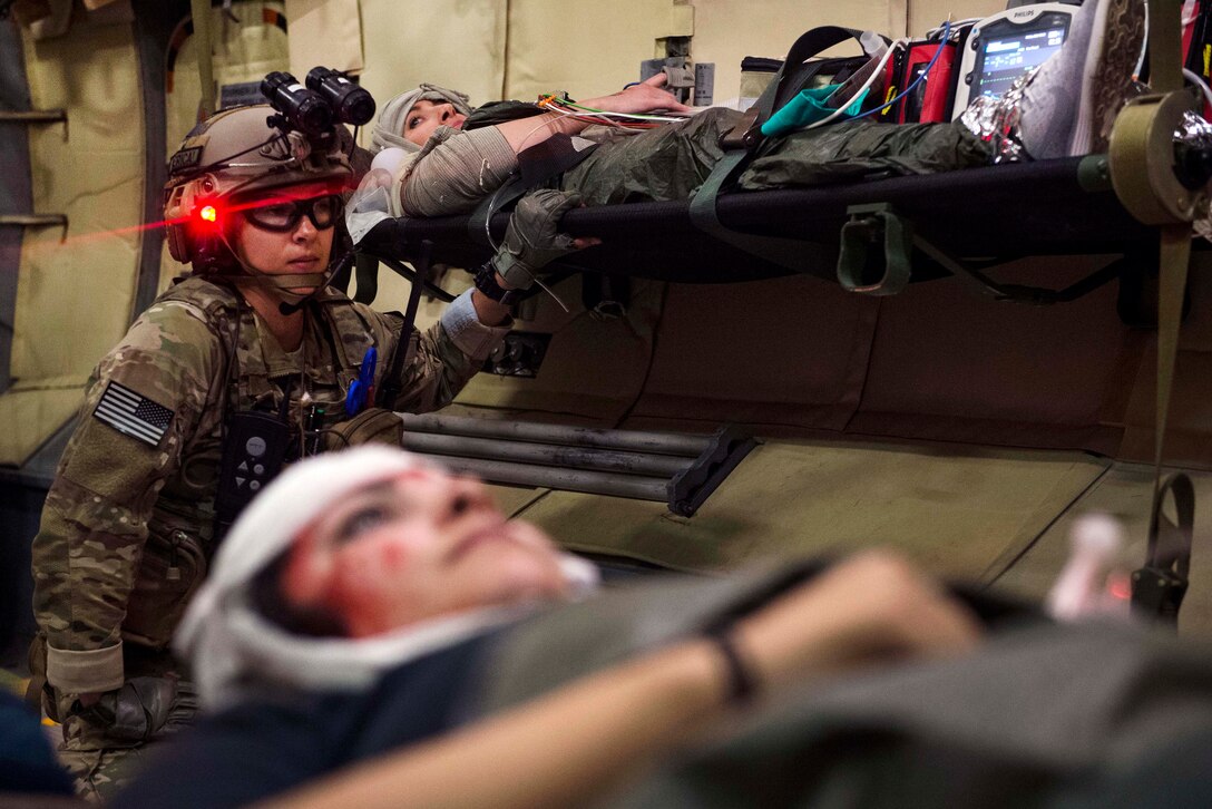 Air Force Tech. Sgt. Renee Snavely, center, braces her patient for landing during Emerald Warrior 17 at Eglin Range, Fla., March 6, 2017. Snavely is an independent duty medical technician assigned to the 1st Special Operations Support Squadron. Air Force photo by Airman 1st Class Nicholas Dutton