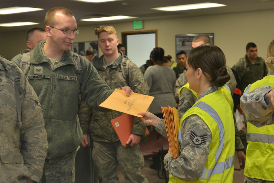 Staff Sgt. Michael Backus, 5th Aircraft Maintenance Squadron, 5th Aircraft Maintenance Squadron instrument and flight control systems craftsman, receives medical documents from Staff Sgt. Jessica Washington, 5th Medical Operations Squadron public health technician at Minot Air Force Base, N.D., March 9, 2017. More than 400 Airmen from the 5th Bomb Wing recently deployed to the Middle East, in support of U.S. Central Command’s Operation Inherent Resolve. (U.S. Air Force photo/Airman 1st Class Jessica Weissman)