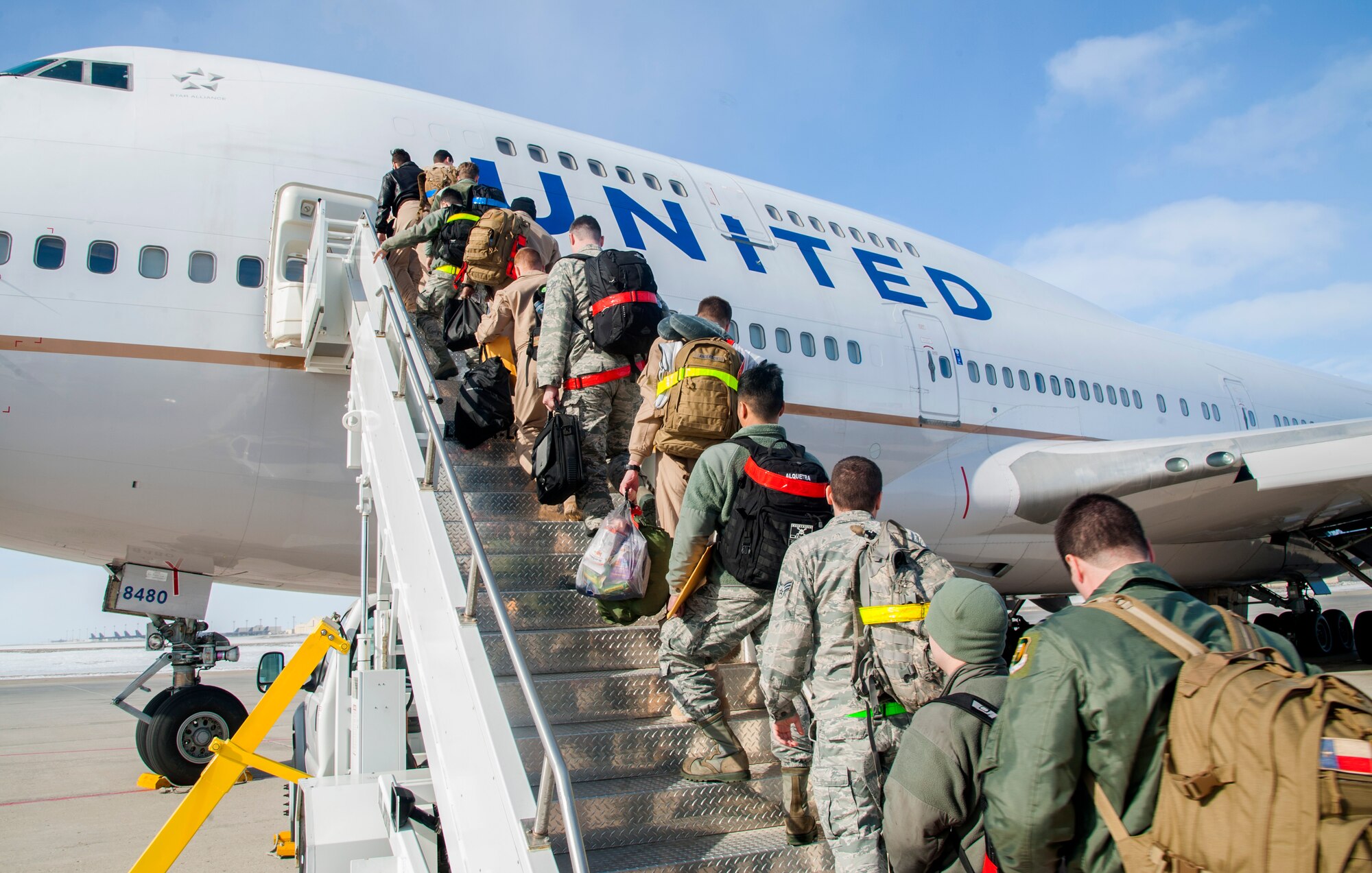 Minot Airmen board a plane during a mass deployment at Minot Air Force Base, N.D., March 9, 2017. Airmen deploy to assure allies, deter adversaries and defeat our enemies. (U.S. Air Force photo/Senior Airman Christian Sullivan)