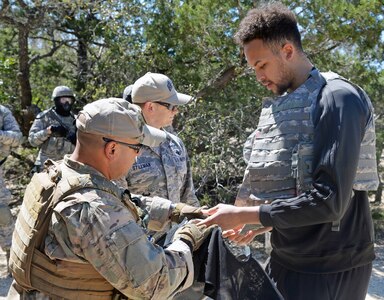 Kyle Anderson of the San Antonio Spurs dons protective gear before seeing what security forces trainees experience during training at Joint Base San Antonio-Camp Bullis March 14.