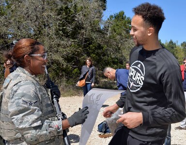 Kyle Anderson of the San Antonio Spurs signs a Spurs banner for a fan during training at Joint Base San Antonio-Camp Bullis March 14. 