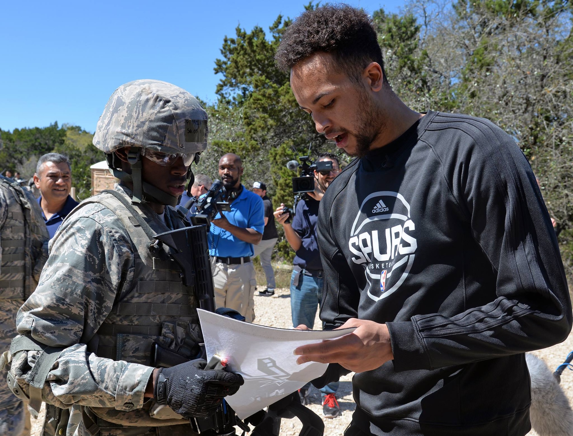 Kyle Anderson of the San Antonio Spurs signs a Spurs banner for a fan during training at Joint Base San Antonio-Camp Bullis March 14. 