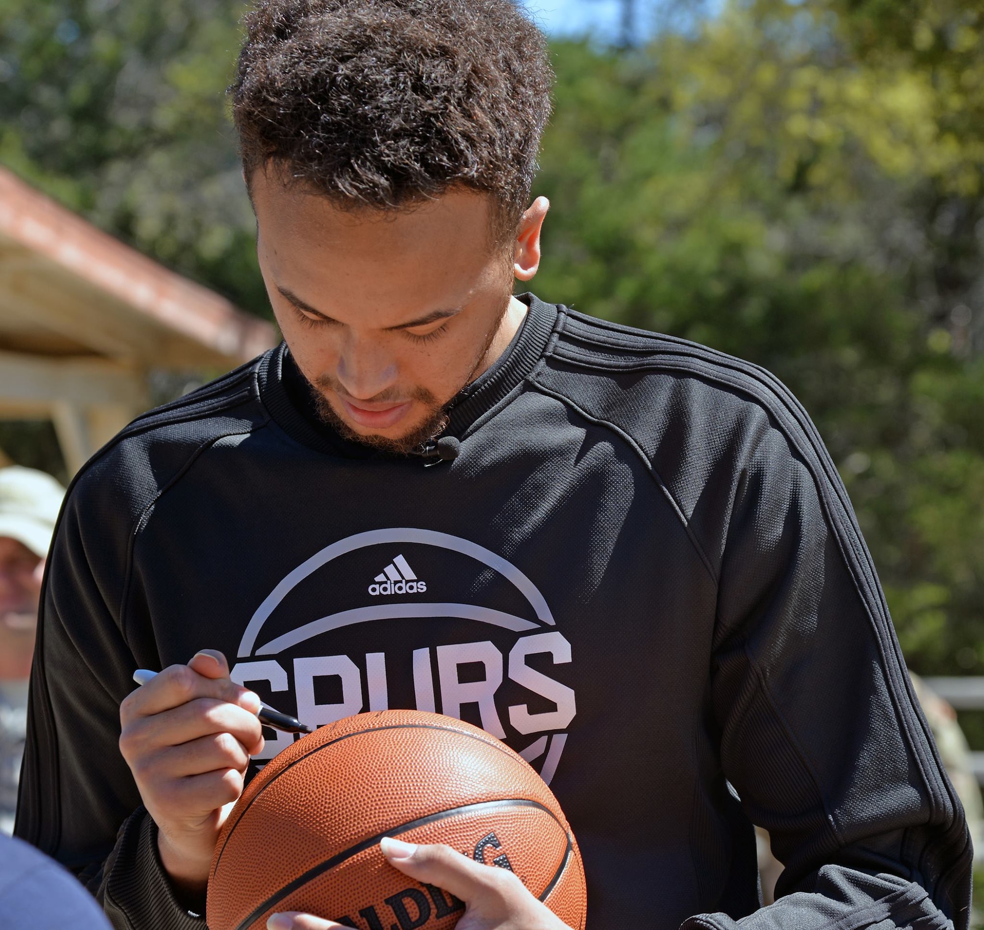 Kyle Anderson of the San Antonio Spurs signs a basketball for the Joint Base San Antonio-Camp Bullis training cadre March 14. 