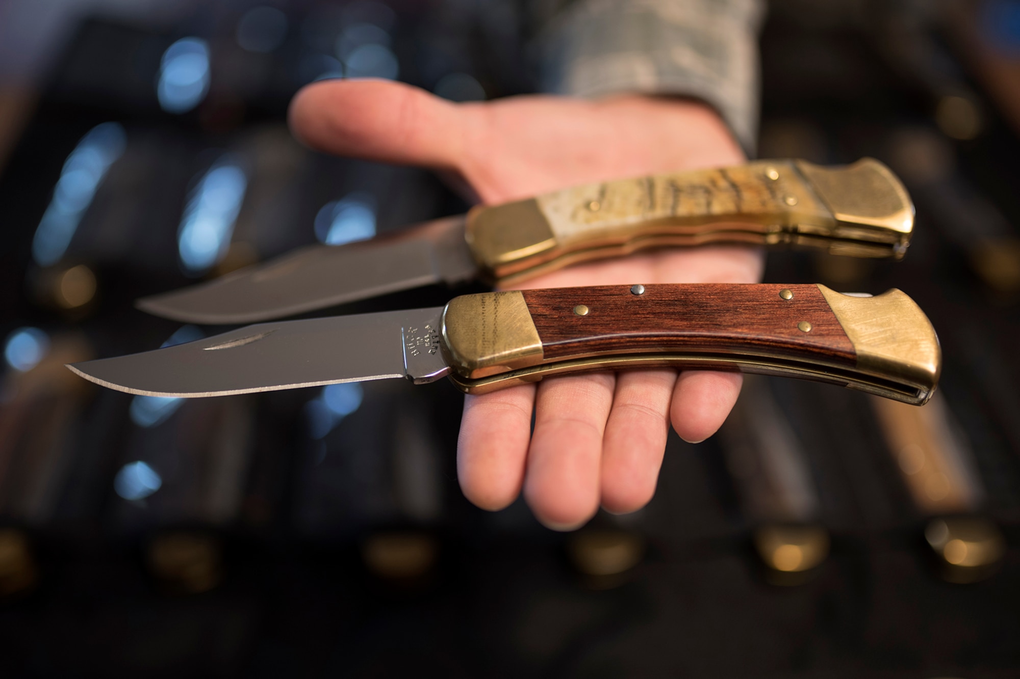 PETERSON AIR FORCE BASE, Colo. – Staff Sgt. Michael Craddock, 21st Space Wing operational security coordinator, holds two buck knives from his collection of more than 350 at his home March 14, 2017. Craddock holds two of his most prized folding knives with his favorite being a custom made blade with a ram’s horn handle (top). (U.S. Air Force photo by Airman 1st Class Dennis Hoffman)