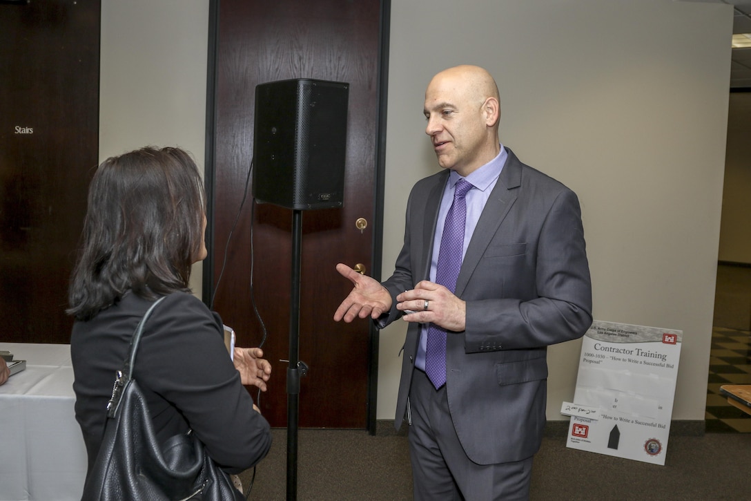 Eric Ravelli, deputy for the Small Business Program, welcomes an attendee to the Los Angeles District Arizona-Nevada Area Office's Business Opportunities Open House March 9 in Phoenix. The event attracted more than 160 attendees from throughout the region. The open house featured morning and afternoon sessions with a contractor training opportunity; successful bid proposal.