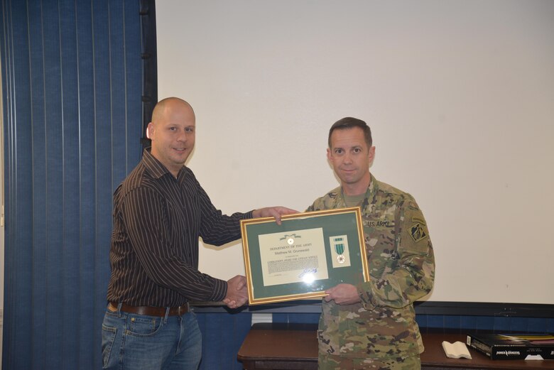 Mobile District Commander Col. James DeLapp presents archeologist Matt Grunewald with the Commander’s Award for Civilian Service Mar. 8 in Mobile, Ala. Grunewald received the award for his outstanding support to the Defense POW/MIA Accounting Agency during a POW/MIA recovery operation in Vietnam last year.