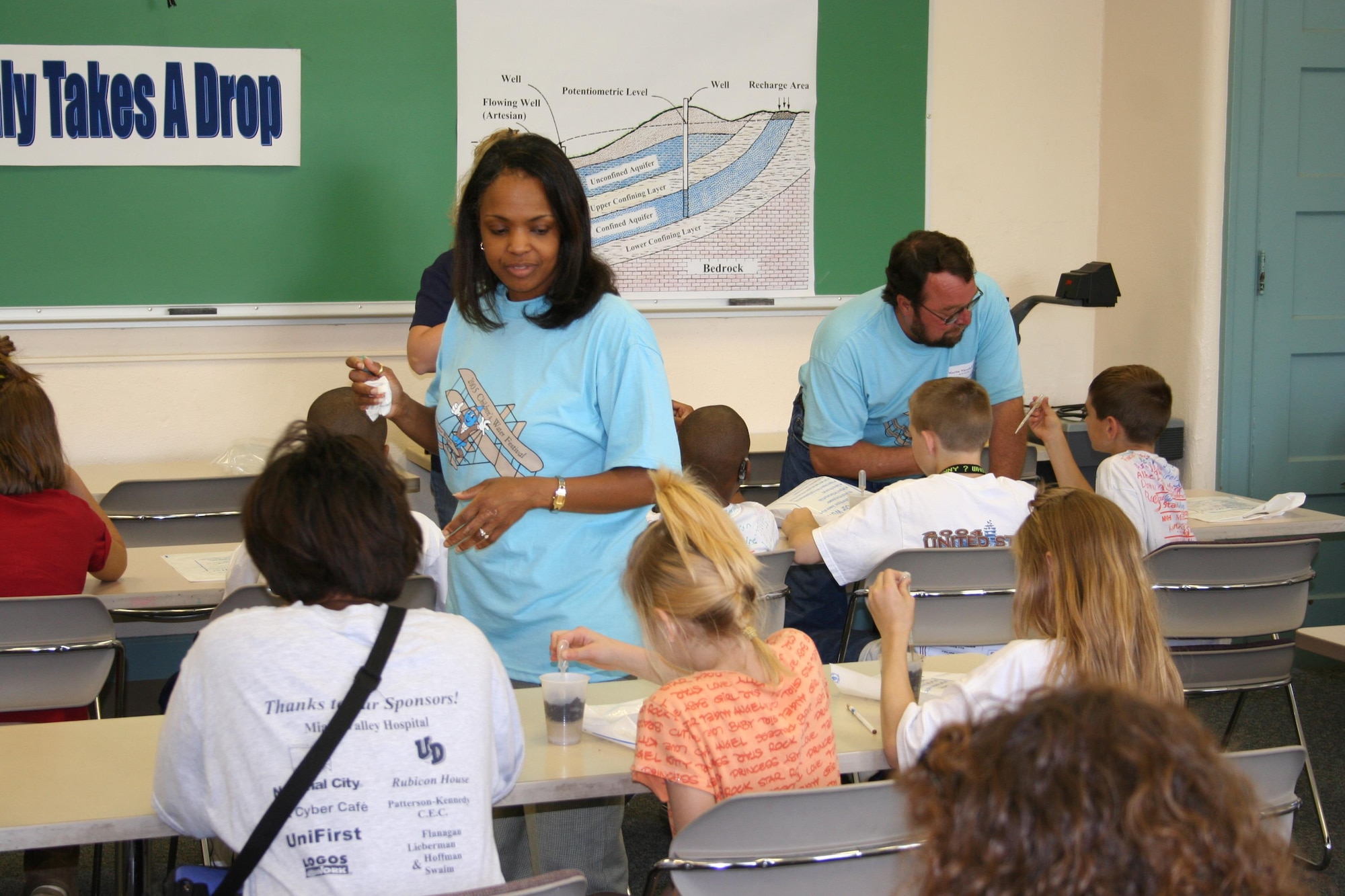 Karen Beason, daughter of Phyllis Bolds, participates in the City of Dayton's Children's Water Festival, held at the University of Dayton, assisting students with an experiment that shows the  importance of protecting our primary source of this area's regional drinking water supply. The festival is a one-day event for students from the 4th grade level that offers a series of continuous presentations on groundwater, surface water, conservation, land use, and other water related topics, various games, experiments, exhibits, and entertainment.  More than 1,700 students, teachers, presenters, and volunteers participate in this remarkable learning experience. (Courtesy photo)