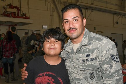Staff Sgt. Juan Nunez a security forces specialist with the 136th Security Forces Squadron, Texas Air National Guard, and his son Tristan pose for a photo at the 136th Airlift Wing’s Annual Children’s Christmas party Nov. 20, 2016 at Naval Air Station Fort Worth Joint Reserve Base, Texas. (