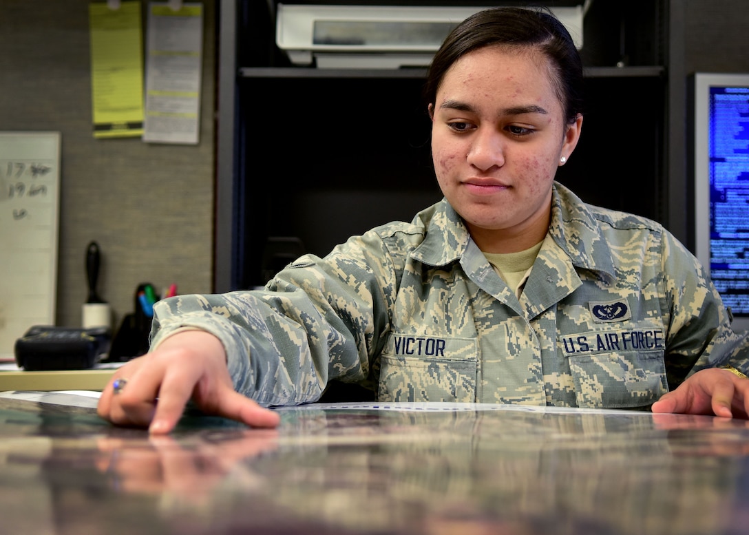U.S. Air Force Airman Gabrielle Victor, Civil Engineer Squadron engineering technician, looks at a map at Joint Base Langley-Eustis, Va., March 14, 2017. Victor is a member of the mapping section, which has more than 45,000 drawings that are kept and maintained, to include all on-base facilities and floor plans. (U.S. Air Force photo/Senior Airman Areca T. Bell)