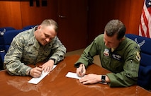Chief Master Sgt. Shane Wagner, 4th Fighter Wing command chief, and Col. Christopher Sage, 4th FW commander, sign their donation forms for the 2017 Air Force Assistant Fund. The AFAF is an Air Force-wide campaign that generates donations for four different charities: Air Force Villages, Air Force Enlisted Villages, The General and Mrs. Curtis E. Lemay Foundation and the Air Force Aid Society. (U.S. Air Force photo by Airman 1st Class Kenneth Boyton)